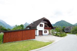 a house with a wooden fence and a driveway at Holiday apartment Pika in Bovec