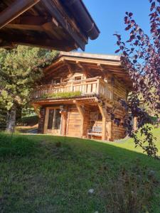 a log cabin with a balcony on top of it at BARMADZA Mazots de Charme in Demi-Quartier