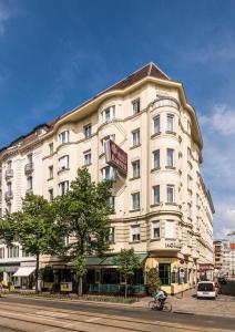 un gran edificio blanco en la esquina de una calle en Hotel Erzherzog Rainer en Viena