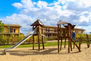 Ein Junge, der auf einer Rutsche auf einem Spielplatz spielt in der Unterkunft Ferienpark Templin direkt neben der Naturtherme in Templin