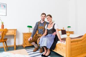a man and a woman sitting on a bed at Brauerei und Gasthof Frischeisen in Kelheim +4 photos