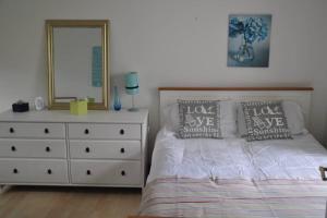 um quarto com uma cama e uma cómoda com um espelho em Pembroke Townhouse em Pembrokeshire