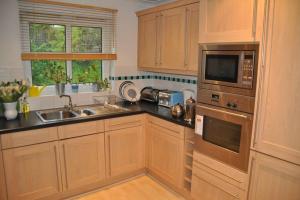 cocina con fregadero y microondas en Pembroke Townhouse, en Pembrokeshire