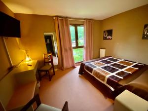 Schlafzimmer mit einem Bett und einem Fenster in der Unterkunft Hotel - Restaurant de la Paix in Barbotan-les-Thermes
