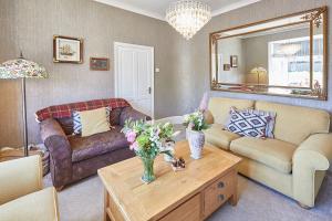a living room with a couch and a table with flowers at Host & Stay - The Beach House in Marske-by-the-Sea