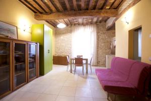 a living room with a purple couch and a table at LE DIMORE ARCANGELO Maria in Assisi +44 photos