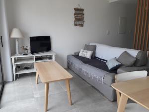 a living room with a couch and a tv at La Cabane Manon in La Guérinière
