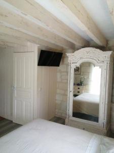 a bedroom with a white bed and a mirror at La Motelle N 5 in Les Ulmes