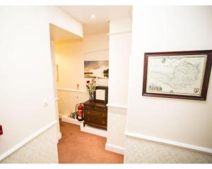 a hallway with a map on the wall and a dresser at Parasol Weston Guest House in Weston-super-Mare