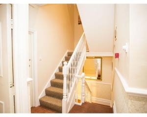 a white staircase in a home with a window at Parasol Weston Guest House in Weston-super-Mare