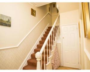 a staircase in a house with a white door at Parasol Weston Guest House in Weston-super-Mare