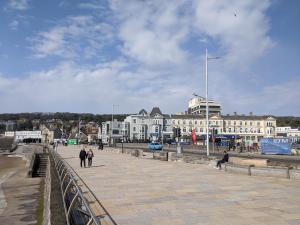 a group of people walking on a bridge with buildings at Parasol Weston Guest House in Weston-super-Mare