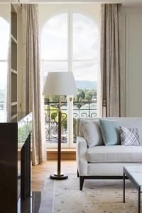 a living room with a couch and a large window at The Woodward - an Oetker Collection Hotel in Geneva