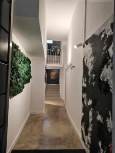 un pasillo con paredes blancas y una escalera con plantas verdes en ANDALUCIA Modern y Luxury, en Sevilla