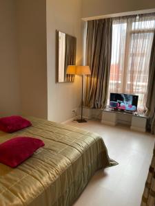 a bedroom with a bed and a lamp and windows at Апартаменты Ясная Поляна in Odesa +26 photos