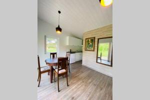 a kitchen and dining room with a table and chairs at Cabin by the river Dubysa! in Ariogala