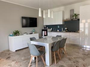 a kitchen with a white table and chairs and a television at Villa Kola B&B in Agrigento