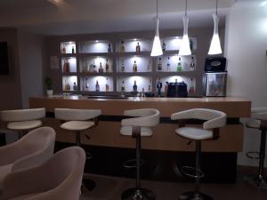 a bar with white stools in a room at SIROS HOTEL in Leptokarya
