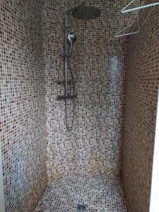 W wyłożonej kafelkami łazience znajduje się prysznic. w obiekcie Villa Maryne w mieście Andernos-les-Bains