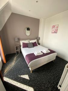 - une chambre avec un grand lit blanc et des oreillers violets dans l'établissement Hôtel du Parc Montsouris, à Paris