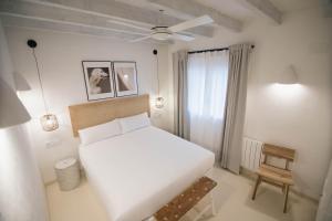 a bedroom with a large white bed and a window at Quinta la Sal in Jávea