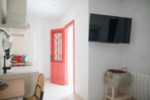 a red door with a television on a white wall at Quinta la Sal in Jávea