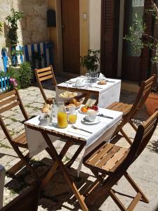 a table with plates of food on it with two chairs at B&B DIMORA PALMIERI in Monopoli