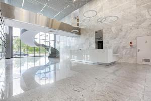 a lobby with a spiral staircase in a building at Apartments with parking Warsaw Business Center by Noclegi Renters in Warsaw +20 photos