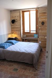 um quarto com uma cama grande e uma janela em Maison du Lys en Layon em Les Cerqueux-sous-Passavant