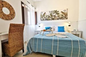 une chambre avec un lit bleu et une chaise dans l'établissement Loft Cocorito - 100 metri dalla spiaggia di sabbia bianca e dal mare, à Fontane Bianche