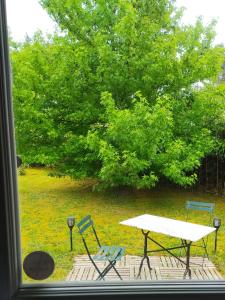 a table and chairs and a picnic table and a tree at Villa Maryne in Andernos-les-Bains