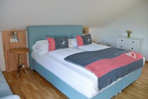 a bed with a blue headboard and red and white blanket at Alpine Appartement Top 8 by AA Holiday Homes in Tauplitz