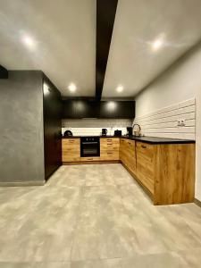 a large kitchen with wooden cabinets and appliances at Istebna Pełna Chata II in Istebna +27 photos