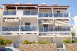 an apartment building with balconies and tables at Blue Senses Apartments in Sarti