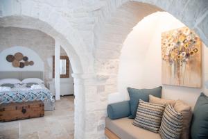 ein Schlafzimmer mit einem Bett und einem Sofa in einem Zimmer in der Unterkunft Chiancole - Trulli Experience in Alberobello