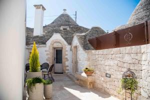 阿尔贝罗贝洛Chiancole - Trulli Experience的一座石制建筑,种植了盆栽植物