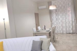 sala de estar con mesa y sofá blanco en Apartment Miriade, en Balestrate