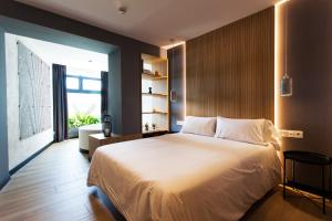 a bedroom with a large bed and a large window at Hospedium H Cabo Sport in Finisterre