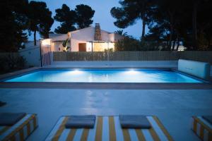 a swimming pool at night with a house in the background at Quinta la Sal in Jávea