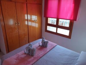 a bedroom with a bed with two pairs of baby shoes on it at Penthouse Residencial Virginia in Torrevieja