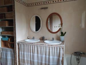 a bathroom with two sinks and two mirrors at Villa Maryne in Andernos-les-Bains