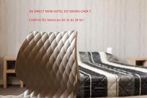 a chair in front of a bed in a room at The Originals City, Hôtel Le Savoy, Caen (Inter-Hotel) in Caen