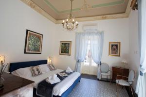 a bedroom with a bed and a chandelier at Palazzo d'Autore - Luxury Home - Ragusa Centro in Ragusa