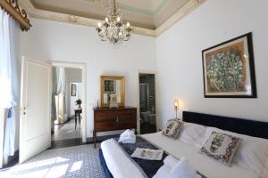 1 dormitorio con cama y lámpara de araña en Palazzo d'Autore - Luxury Home - Ragusa Centro, en Ragusa