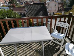 een witte tafel en 2 stoelen op een balkon bij Gite Louvre Opale in Desvres
