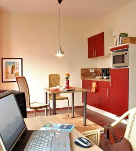 a kitchen with a table with a laptop on it at Boardinghouse am Rosensee in Aschaffenburg