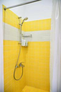 y baño con ducha y pared de azulejos amarillos. en Caravan, en Türkistan
