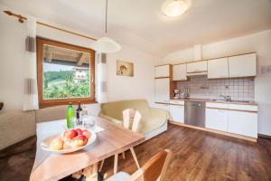 a kitchen and living room with a table with a bowl of fruit at Langeshof Fewo Abendrot in Caines
