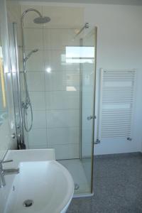 uma casa de banho com um chuveiro e um lavatório branco em Værelse i Augustenborg i stor villa em Augustenborg