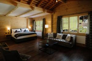 a bedroom with a bed and a couch in a room at Bodehüttli in Adelboden